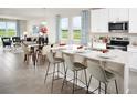 Bright, open-concept kitchen with a large island, modern appliances, and an adjacent living area at 193 Lazy Shore Dr, Nokomis, FL 34275