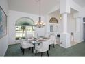 Elegant dining room with a modern chandelier, stylish furniture, and large windows at 470 Bermuda Isles Cir, Venice, FL 34292