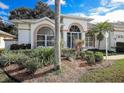 Lush front yard with decorative landscaping and mature trees in a well-maintained community at 470 Bermuda Isles Cir, Venice, FL 34292