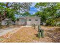 Charming single-story home featuring mature trees and unique front yard details at 912 Magnolia Dr, Clearwater, FL 33756