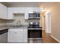 Bright kitchen featuring stainless steel appliances, white cabinets, and granite countertops at 912 Magnolia Dr, Clearwater, FL 33756