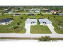 Overhead view showcases two homes with paved driveways surrounded by landscaped yards in a peaceful neighborhood at 221 Rotonda S Blvd, Rotonda West, FL 33947
