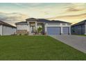 Charming single-Gathering home featuring a manicured lawn, stone accents, and a three-car garage at 235 Rotonda S Blvd, Rotonda West, FL 33947
