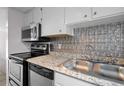 Traditional kitchen with stainless steel appliances, granite countertops, and decorative backsplash at 5112 Temple Heights Rd # B, Tampa, FL 33617