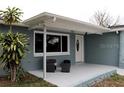 Welcoming front porch with a seating area and white framed window and door at 3841 Chaffey Dr, New Port Richey, FL 34652