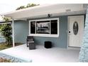 Inviting front porch with a seating area, large window, and a white front door at 3841 Chaffey Dr, New Port Richey, FL 34652