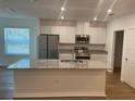 Modern kitchen features an island, stainless steel appliances, granite countertops, and white cabinets at 11330 Godwit Ave, Weeki Wachee, FL 34613