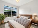 A modern bedroom with light wood furnishings, large window, and neutral color palette offers a serene retreat at 3403 30Th E Ln, Bradenton, FL 34208