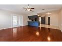 Open-concept living area with hardwood floors, leading to kitchen and bright sliding glass doors at 1117 Mook St, Brandon, FL 33510