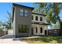 Two-story home with gray and white exterior, well-manicured lawn, and concrete driveway at 4115 N Central Ave, Tampa, FL 33603