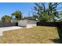 Detached white garage with black accents, surrounded by a well-maintained lawn and dark fencing at 4115 N Central Ave, Tampa, FL 33603