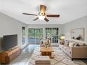 Bright living room features neutral décor, stylish furniture, and a ceiling fan, creating a comfortable space at 6902 Lakeview Ct, Tampa, FL 33634