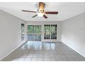 Bright, open living room featuring tiled flooring and glass doors leading to a screened patio at 6902 Lakeview Ct, Tampa, FL 33634