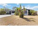 Well-maintained home with tropical landscaping, a spacious driveway, and a welcoming facade at 75 Virginia Ct, Englewood, FL 34223