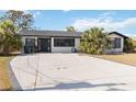 Well-maintained home with a wide driveway, mature trees, and a newly painted exterior at 75 Virginia Ct, Englewood, FL 34223