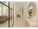 Bright hallway with modern decor, stylish mirror, sleek console table, and porcelain flooring at 1966 Hyde Park St, Sarasota, FL 34239