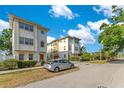 Townhouses featuring a cream and yellow exterior with a blue sky backdrop and street view at 4409 W Gray St # 5, Tampa, FL 33609