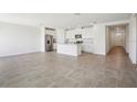 Open-concept living space featuring tile flooring, neutral walls, and a modern kitchen with stainless steel appliances at 7740 Gilchrist Springs Dr, Parrish, FL 34219