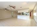 Open-concept living room with tiled floors, ceiling fans, and seamless flow into the kitchen at 12408 Golden Oak Cir, Hudson, FL 34669