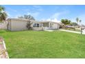 Attractive single-story home with lush green lawn, a driveway, and a quaint front patio at 8506 Moulton Dr, Port Richey, FL 34668
