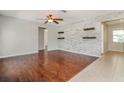 Inviting living room with hardwood floors, a faux wood plank wall, and modern ceiling fan at 8506 Moulton Dr, Port Richey, FL 34668