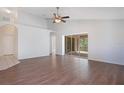 Bright living room featuring hardwood floors, vaulted ceilings, and a sliding glass door to the lanai at 5009 72Nd E Ct, Bradenton, FL 34203