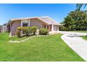 Landscaped front yard featuring a well-maintained lawn and complementary foliage at 7221 King Arthur Dr, Port Richey, FL 34668