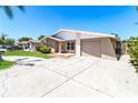 Charming single-story home featuring a well-maintained lawn, driveway, and attached garage at 7221 King Arthur Dr, Port Richey, FL 34668