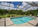 Beautiful screened pool with tiled deck and serene backyard view at 9475 Dunkirk Rd, Spring Hill, FL 34608