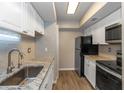 Updated kitchen featuring stainless steel appliances, granite counters, subway tile backsplash, and white cabinets at 2597 Countryside Blvd # 204, Clearwater, FL 33761