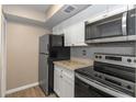 Bright kitchen features stainless steel appliances, wood-style floors, and white cabinets at 2597 Countryside Blvd # 204, Clearwater, FL 33761
