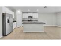 Bright kitchen features stainless steel appliances, granite countertops, and large island with sink at 10357 Scarlet Skimmer Dr, Riverview, FL 33578