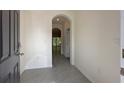 Inviting entryway with neutral colored walls, tile flooring, leading into open living space, and a transom doorway at 1570 Hubbell Rd, Wesley Chapel, FL 33543