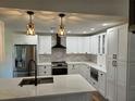 Bright modern kitchen with stainless steel appliances, white cabinets, and stylish pendant lighting at 2055 Lakeview Dr, Clearwater, FL 33763