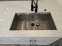 Close-up of modern kitchen sink with white countertop and black faucet at 2055 Lakeview Dr, Clearwater, FL 33763