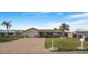 Single-story home with brick driveway and lush, green lawn, offering a welcoming exterior at 4043 Topsail Trl, New Port Richey, FL 34652
