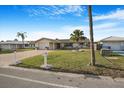 Single-story home boasts a brick driveway, green lawn, and mature palms in a well-maintained front yard at 4043 Topsail Trl, New Port Richey, FL 34652