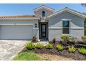 Beautiful front of home with a two-car garage and stone-paved walkway at 507 Daylily Blvd, Nokomis, FL 34275