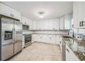 Modern kitchen featuring stainless steel appliances, granite countertops, and white cabinets at 5817 26Th W St, Bradenton, FL 34207