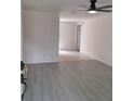 Inviting living room with light gray wood flooring, ceiling fan, and an open doorway to tiled kitchen at 3716 Mistwood Dr, Tampa, FL 33619