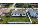 An aerial view captures a home nestled among neatly fenced yards and manicured green lawns at 20296 Rutherford Ave, Port Charlotte, FL 33952