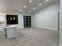 Spacious living room featuring vaulted ceilings, modern lighting, and wood-look tile flooring at 20296 Rutherford Ave, Port Charlotte, FL 33952