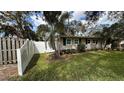 Side view of a charming home with a white picket fence and green shutters at 3141 Irving St, Sarasota, FL 34237