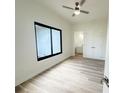 Bright bedroom with wood flooring, ceiling fan, and a large window for ample natural light at 15561 Aldama Cir, Port Charlotte, FL 33981