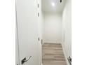 Narrow hallway featuring wood flooring and white walls with modern hardware and doors at 15561 Aldama Cir, Port Charlotte, FL 33981