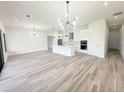 Open-concept kitchen and living area featuring an island and modern lighting fixtures over wood flooring at 15561 Aldama Cir, Port Charlotte, FL 33981