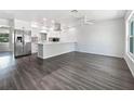 Open-concept living area with wood floors, seamlessly connected to a stylish kitchen at 837 Dolphin Nw Ave, Port Charlotte, FL 33948