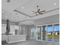 Open-concept living space with tray ceilings, pendant lights, and sliding glass doors at 261 Rotonda S Blvd, Rotonda West, FL 33947