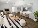 Bright, open-concept living room and kitchen featuring modern finishes and ample seating at 8253 Penwood Dr, Port Richey, FL 34668