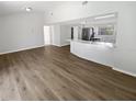 Open-concept living area with laminate flooring, neutral paint, and seamless flow to the breakfast bar and kitchen at 8253 Penwood Dr, Port Richey, FL 34668